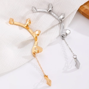 Detailed close-up of Gothic silver and gold ear cuffs with sharp spikes and chains
