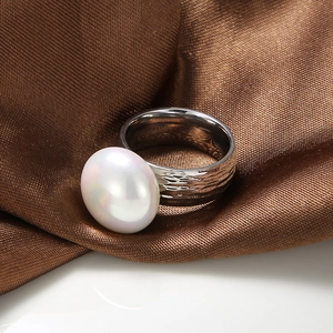 Macro shot of stainless steel ring with baroque hammer texture and white pearl detail