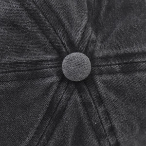 Macro shot of the stitched crown and top button on a black washed cotton baseball cap