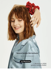 Detail of 22 Momme mulberry silk scrunchie in red on hair with luxury texture