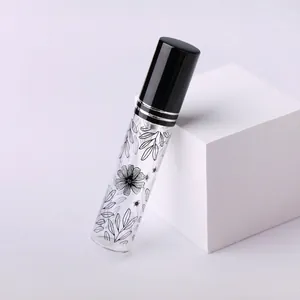 Dettaglio del flacone di profumo da 10ml in vetro con motivi floreali neri e tappo spray