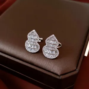 Elegant silver gourd earrings set with shimmering zircon on a premium leather surface