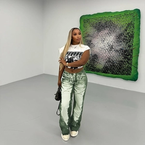 Fashionable green and white tie-dye straight leg pants styled with a white graphic crop top