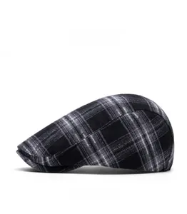 Detail shot of vintage grey plaid beret newsboy cap with classic checkered wool fabric