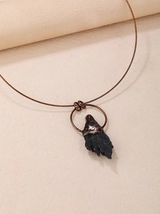 Choker vintage in rame con tormalina nera grezza su uno sfondo in pelle testurizzata