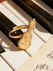 Verstellbarer Ring in Gitarrenform in Gold auf einer klassischen Klaviertastatur