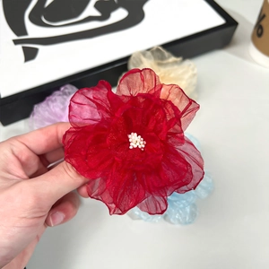 Gros plan détaillé d'une fleur en organza rouge avec de délicats pistils en perles