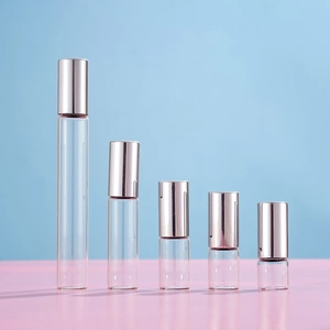Set of five transparent glass roller bottles for essential oils with rose gold metal caps