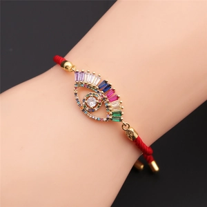 Close-up of red braided evil eye bracelet with colorful zircons and gold plating