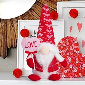 Detail of Valentine gnome plush with red heart hat and pink heart sign labeled LOVE
