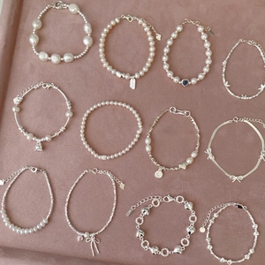 Elegant pearl and silver chain bracelets with heart and butterfly charms on display