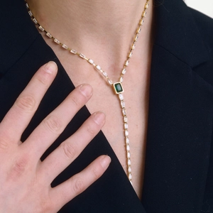 Elegante collar dorado en forma de Y con gemas verdes talla esmeralda y circones blancos