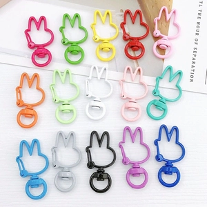 Colorful rabbit-shaped metal keychains in various candy-colored paint finishes on white background
