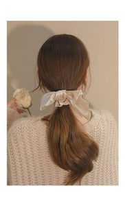 Elegant velvet bow scrunchie in champagne gold worn on a ponytail for a stylish autumn look