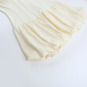 Detail of the light beige balloon hem with delicate pleats and a woven fabric finish