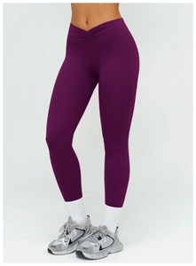 Détail de la taille haute plissée en V sur un legging de yoga de couleur violet foncé