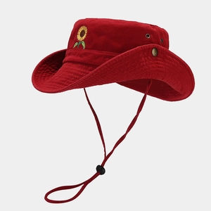 Detail of red cotton sun hat with sunflower embroidery, metal eyelets and chin strap