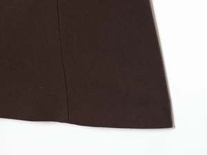 Macro shot of dark brown top showing fine stitching and smooth woven fabric texture