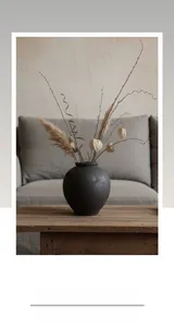 Detalle de jarrón de cerámica negro mate con textura arenosa sobre banco de madera
