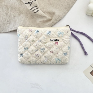 Close-up of quilted floral coin purse with rabbit pattern and purple woven handle