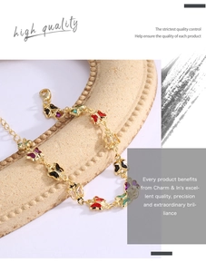 Detail of gold brass bracelet with vibrant colorful acrylic butterfly charms