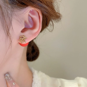 Close-up of golden Chinese character Fa earrings on model for Lunar New Year