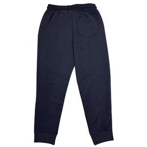 Macro detail of men's dark joggers showing diamond quilted fabric and ribbed ankle cuffs
