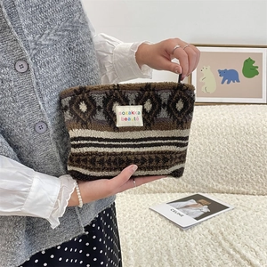 Detail view of a stylish plush cosmetic bag with tribal patterns and a soft texture.