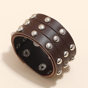 Detailed view of punk brown leather bracelet with three rows of silver round studs