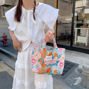 Détail du sac fourre-tout en toile à fleurs avec étiquette Love Sozakka et anses robustes