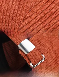 Detail of orange corduroy baseball cap showing fine stitching and adjustable metal buckle