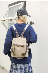 Rear view of a beige nylon backpack featuring leopard print straps and tassel details