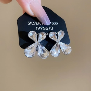 Detailed view of silver flower stud earrings with clear crystals on a black card