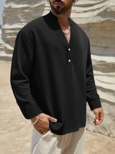 Detail of black cotton linen Henley shirt featuring two-button V-neck and casual texture