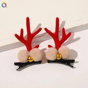 Detailed view of red reindeer antler hair clips with plush balls and gold bells