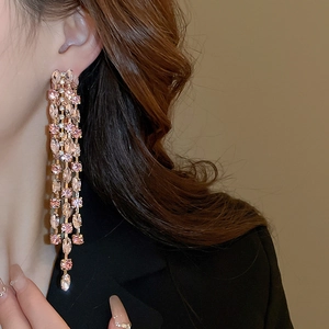 Detail view of long pink crystal fringe earrings with multi-layered tassel design