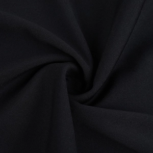 Gros plan sur un tissu noir texturé avec d'élégants détails froncés et coutures