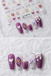Detail of 3D embossed nail stickers featuring purple floral and heart patterns