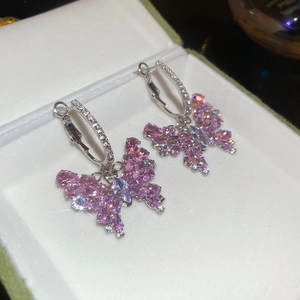 Dettaglio di orecchini a cerchio a farfalla in argento con pendenti in zircone rosa brillante