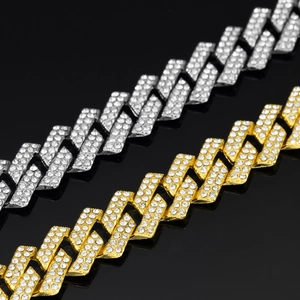 Detailed close-up of gold and silver cuban link chains with sparkling crystal pavé setting