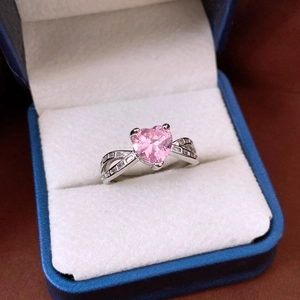 Detailed macro of a pink heart-shaped gemstone ring with a twisted silver band
