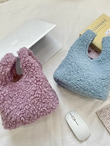 Chic teddy fleece handbags in lavender and light blue displayed with laptop on desk