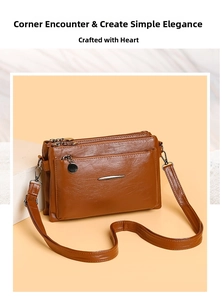 Detail of brown faux leather crossbody bag showing multi-zipper layers and fine texture