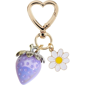 Detail of a purple strawberry and white daisy charm on a gold heart-shaped keychain