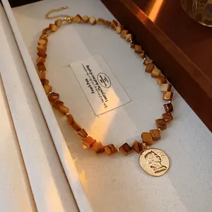 Vintage necklace with square brown beads and a gold portrait coin pendant