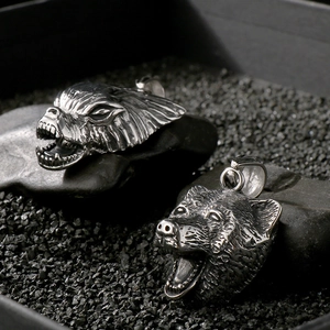 Detailed macro shot of vintage silver wolf head pendants with textured punk finish
