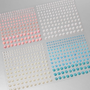 Detail view of 4 sheets of mixed-size round pearl stickers in pink, white, cream, and blue