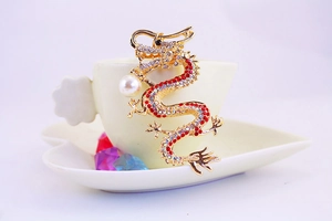 Macro detail of golden dragon keychain with red rhinestones and a white pearl accent