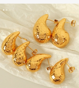 Detailed close-up of gold chunky waterdrop earrings with textured hammered finish on white