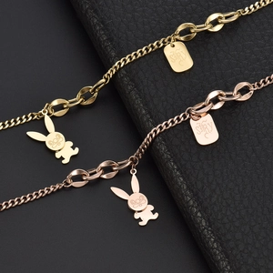 Detail of gold and rose gold snake chains with rabbit charms and STORY tags on leather